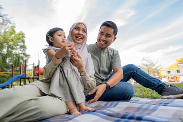 Happy Muslim Family Have A Picnic Outdoor  - obrazy, fototapety, plakaty