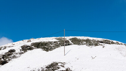 Poste eléctrico en valle de montañas nevadas