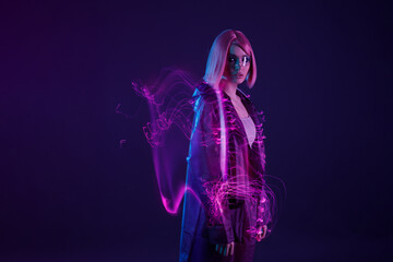 Woman in futuristic costume. Female in modern VR glasses interacting with network while having virtual reality experience. Augmented reality game, future technology, AI concept. VR. Neon purple light. - obrazy, fototapety, plakaty