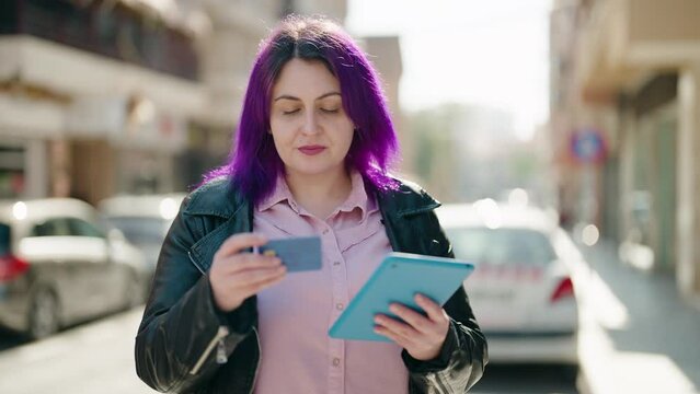 Young plus size woman using touchpad and credit card at street