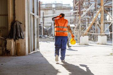 Obraz na płótnie Canvas Multiracial man working hard at construction industry plant