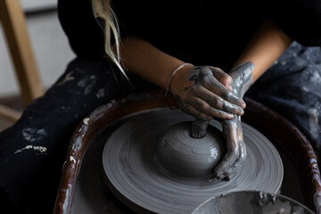 Young woman doing handmade pottery on the potter's wheel. Artist at work