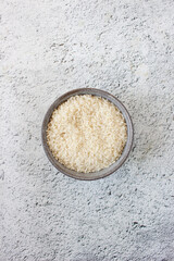 grey bowl with rice on background with copy space for your text, top view. Natural food high in protein