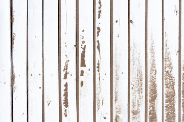 Background of white painted rustic wooden slats arranged vertically, dirty with sand.