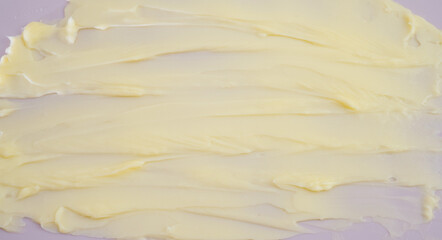 Cosmetic products creamy yellow stain texture on pink background. Texture of natural cosmetics,...