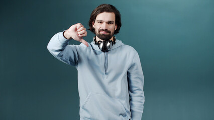 A young beautiful man is gesturing and looking at the camera