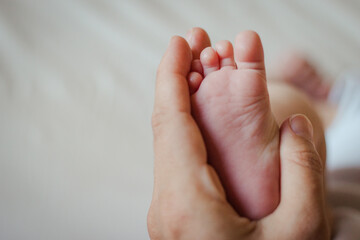 foot of newborn and hand of the parent