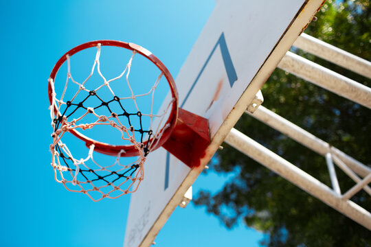 Colourful image of basketball hoop in sunny day. Close-up down view.