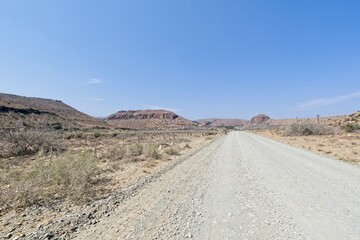 Gravel road towards the hills in the distance