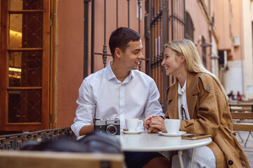 Portrait of lovely couple sitting at outdors cafe and talking