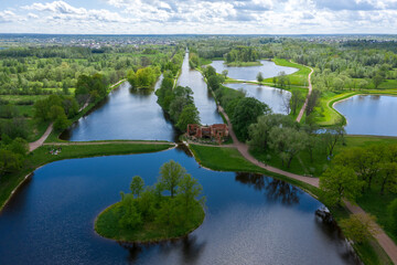 Obraz premium A panoramic view from a height of the ponds and the Landscape Park in Peterhof, the meadow garden, walking paths, the destroyed pavilion.