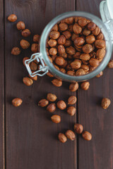 Close up brown hazel nut in glass jar and on wooden desk. Healthy organic vegetarian snack hazelnut