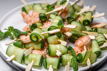 Canapes with cucumber and shrimp on a large plate.