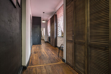 long corridor in interior of entrance hall of modern apartments with doors, cabinets, shelves and a mirror