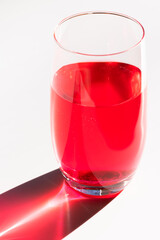 Caustic on white surface of glass with liquid, optical effect.