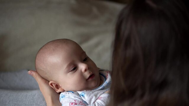 Newborn Baby With Young Mom look Into Each Other Eye. Cute Smiling Teethless Kid Face Portrait. Woman Kissing With Child Look At Camera. Infant, Mother Day, Childbirth, Beginning, Relationship Concept