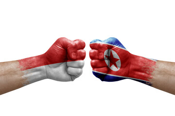 Two hands punch to each others on white background. Country flags painted fists, conflict crisis concept between indonesia and north korea