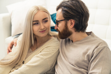Fototapeta na wymiar attractive caucasian long-haired blonde woman in her late 20s flirtatiously looking at her good-looking boyfriend. High quality photo