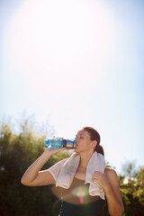 Nothing is more refreshing on a warm day.... An attractive woman drinking from her water bottle after a workout.