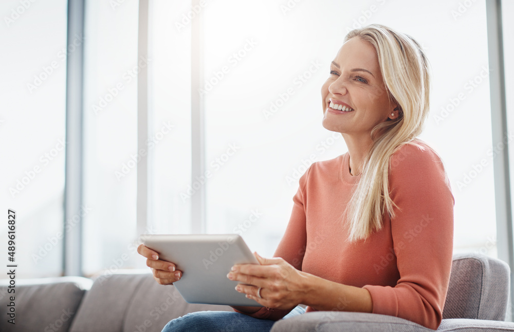 Poster installing relaxation. shot of an attractive mature woman using a digital tablet while relaxing on t