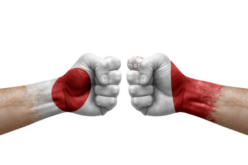 Two hands punch to each others on white background. Country flags painted fists, conflict crisis concept between japan and malta