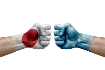 Two hands punch to each others on white background. Country flags painted fists, conflict crisis concept between japan and micronesia