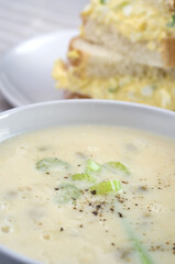 Delicious Celery Soup with Egg Salad Sandwich in the Background