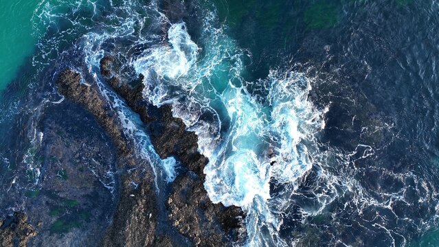 Aerial view of waves and clifs. Ocean waves breaking over rocks, aerial view of drone.