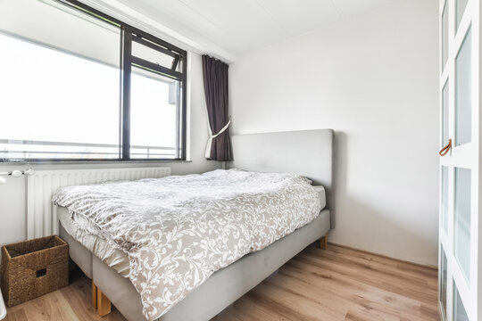 Guest bedroom with single bed with large window overlooking the city