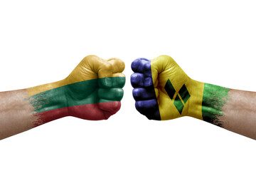 Two hands punch to each others on white background. Country flags painted fists, conflict crisis concept between lithuania and saint vincent and the grenadines