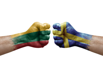 Two hands punch to each others on white background. Country flags painted fists, conflict crisis concept between lithuania and sweden
