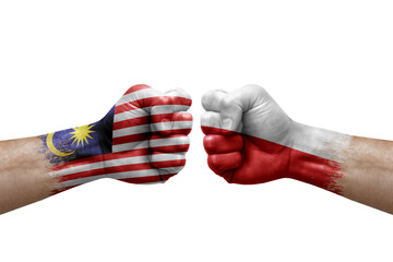 Two hands punch to each others on white background. Country flags painted fists, conflict crisis concept between malaysia and poland