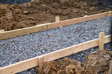 Pedestrian pathway construction in progress lumber guide rails secured with stakes gravel base