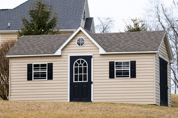 Gray color prefab gardening tools storage shed in the house backyard