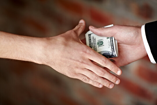 Receiving a bribe. Cropped shot of hands receiving an illegal payoff.