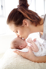 Theres no love like that of a mother. Closeup shot of a mother tenderly kissing her newborn baby.