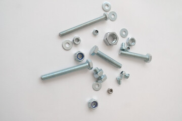 Nuts, screws, bolts are on a white background. Construction tools and parts.