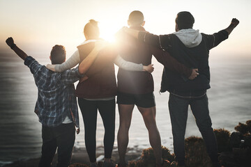Theyre proud of themselves. Rearview shot of a group of friends standing with their arms raised on a mountain cliff.