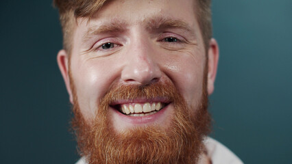 Portrait of a red bearded guy in white classic shirt making faces