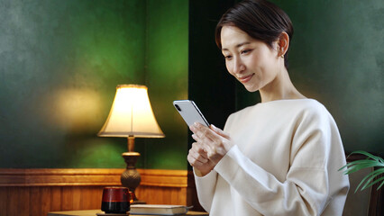 アンティークな部屋でスマートフォンを使う女性