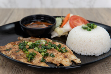 Grilled chicken with iverted rice for a Vietnamese meal served with tradional dressing sauce
