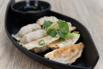 Crispy pot sticker dumplings for a Vietnamese meal appetizer served in a boat