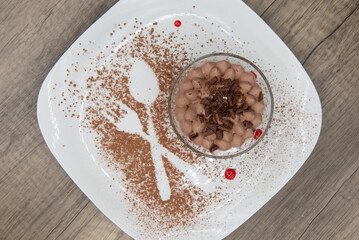 Overhead view of pattern in the chocolate sprinkles on the plate decorates the presentation of the tiramisu dessert