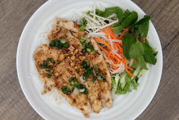 Overhead view of delicious grilled chicken for a Vietnamese meal served with vermicelli in a bowl