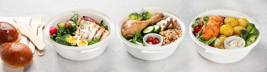 Healthy meal prep in lunch boxes on light background.
