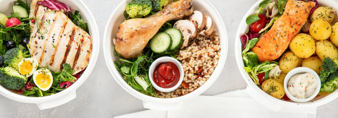 Healthy meal prep in lunch boxes on light background.