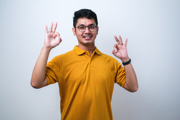 Naklejka premium Adult Asian man showing excited face expression while giving two OK finger sign