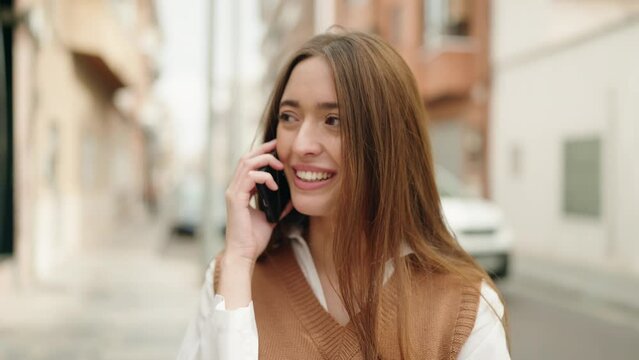 Young hispanic woman smiling confident talking on the smartphone at street