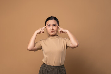 Asian woman feel confuse, standing isolated on beige background.