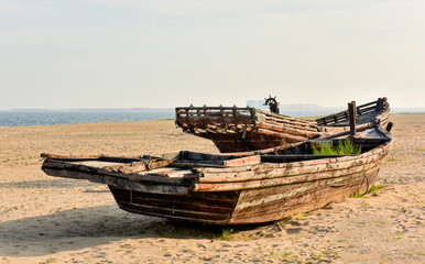 Fototapeta na wymiar Abandoned old boats lie on the beach